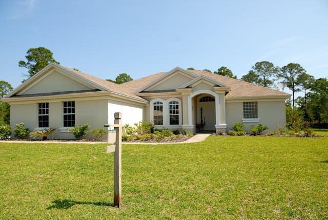 A large house with a sign in the front lawn